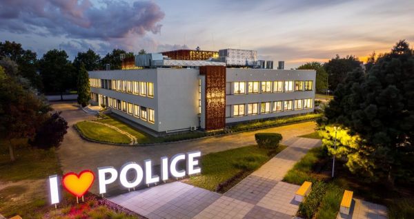Na pierwszym planie neon ILOVEPOLICE, w tle budynek Miejskiego Ośrodka Kultury